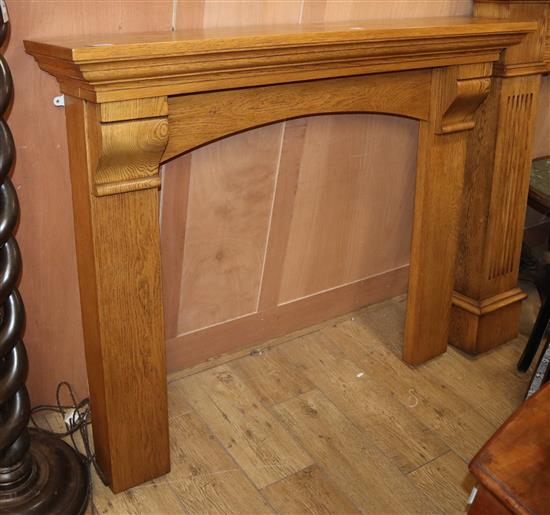 A reproduction oak fire surround, W.137cm H.110cm